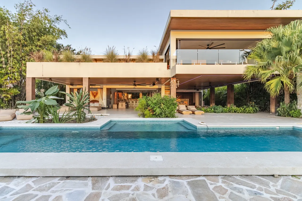 Villa Raya’s timber-lined tropical architecture viewed across the swimming pool